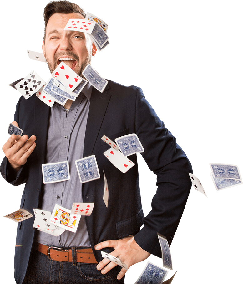 A man in a suit with playing cards flying around him.