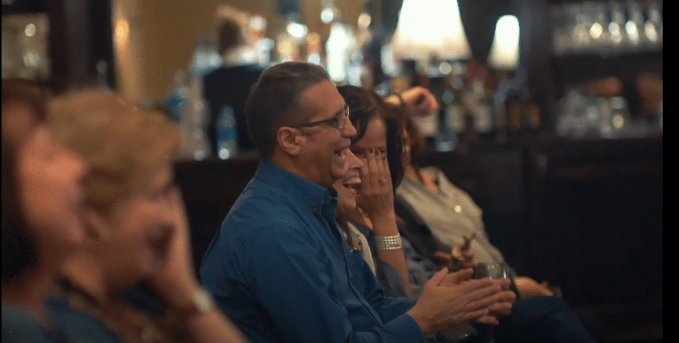 A group of people sitting in a bar enjoying a corporate event.